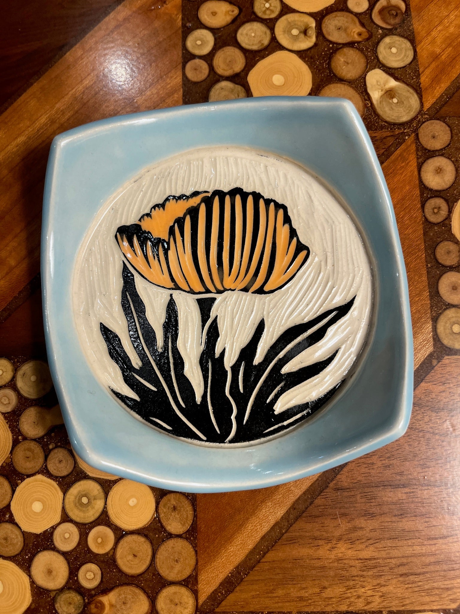 Ceramic plate with floral design on a wooden surface